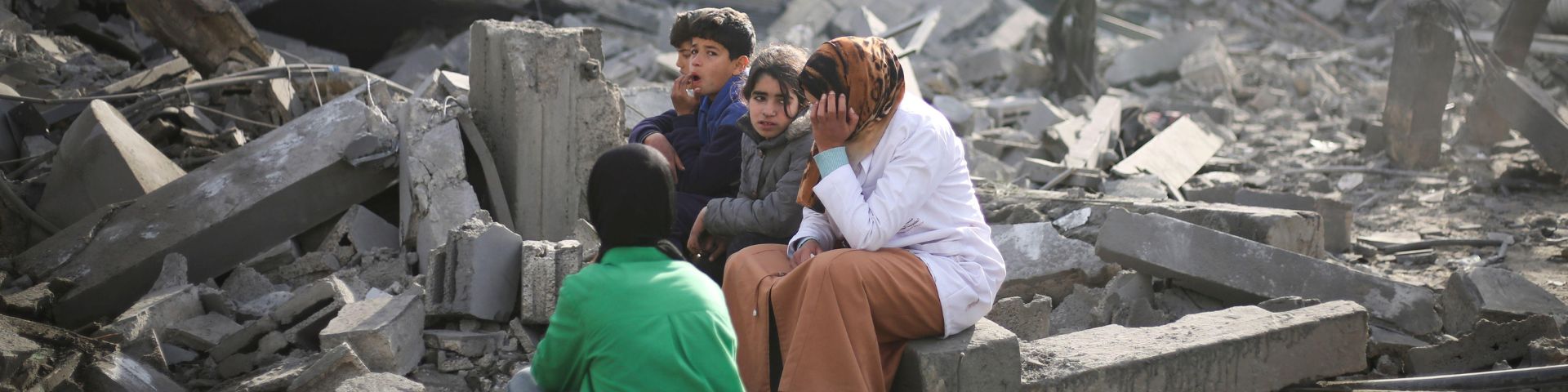 Palestinians sit by the destruction from the Israeli bombardment of the Gaza Strip in Rafah on Monday, Feb. 12, 2024.